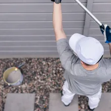 Painter painting a wooden facade