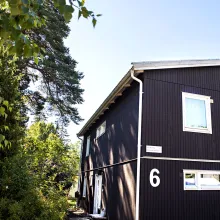 Svart trähus med stora fönster