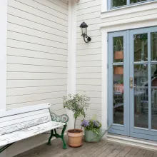 Ett nyvättat grått trähus med terrass