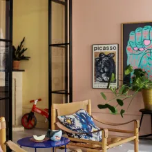 Ett färgstarkt vardagsrum med väggar målade i Old Rose