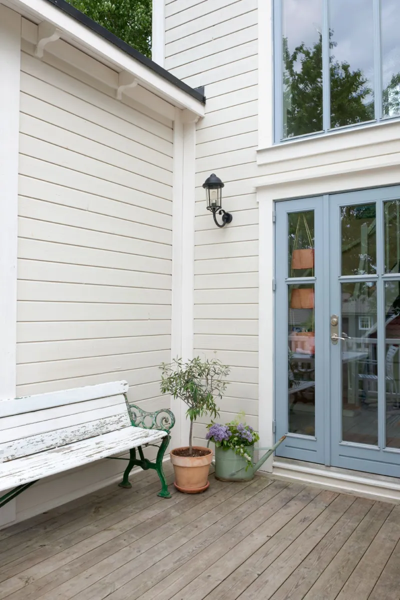 Ett grått trähus med terrass